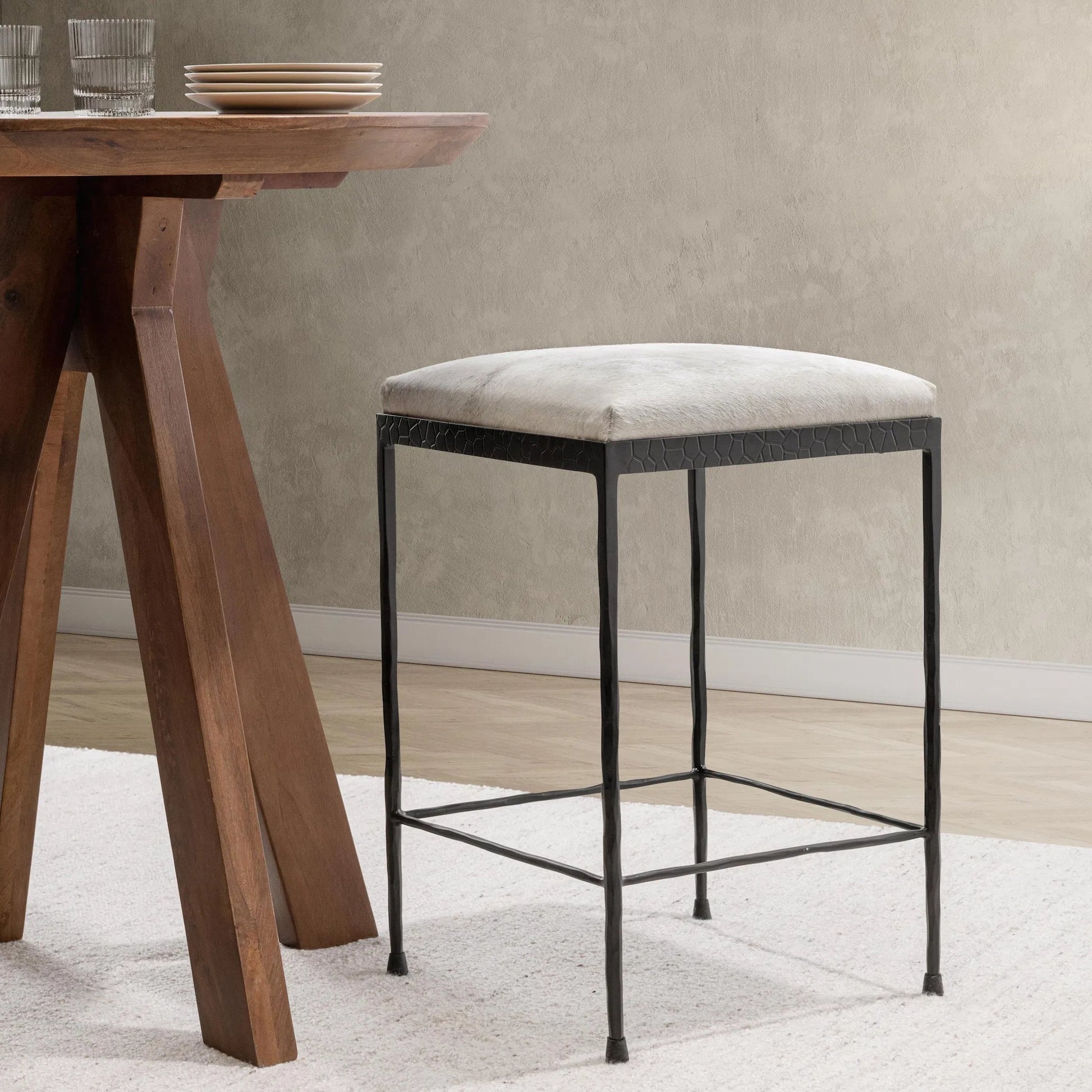 Bose Hide Leather Counter Stool by Classic Home. Made from embossed hammered iron, hair on hide in a modern style.