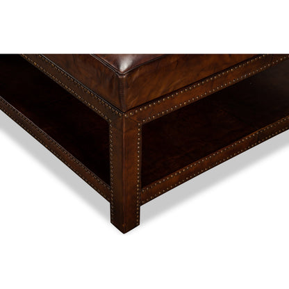 Vintage Tufted Ottoman by Sarreid Ltd. in black and old brown leather brass tacks. Made from hardwood, leather, brass in a rustic style.