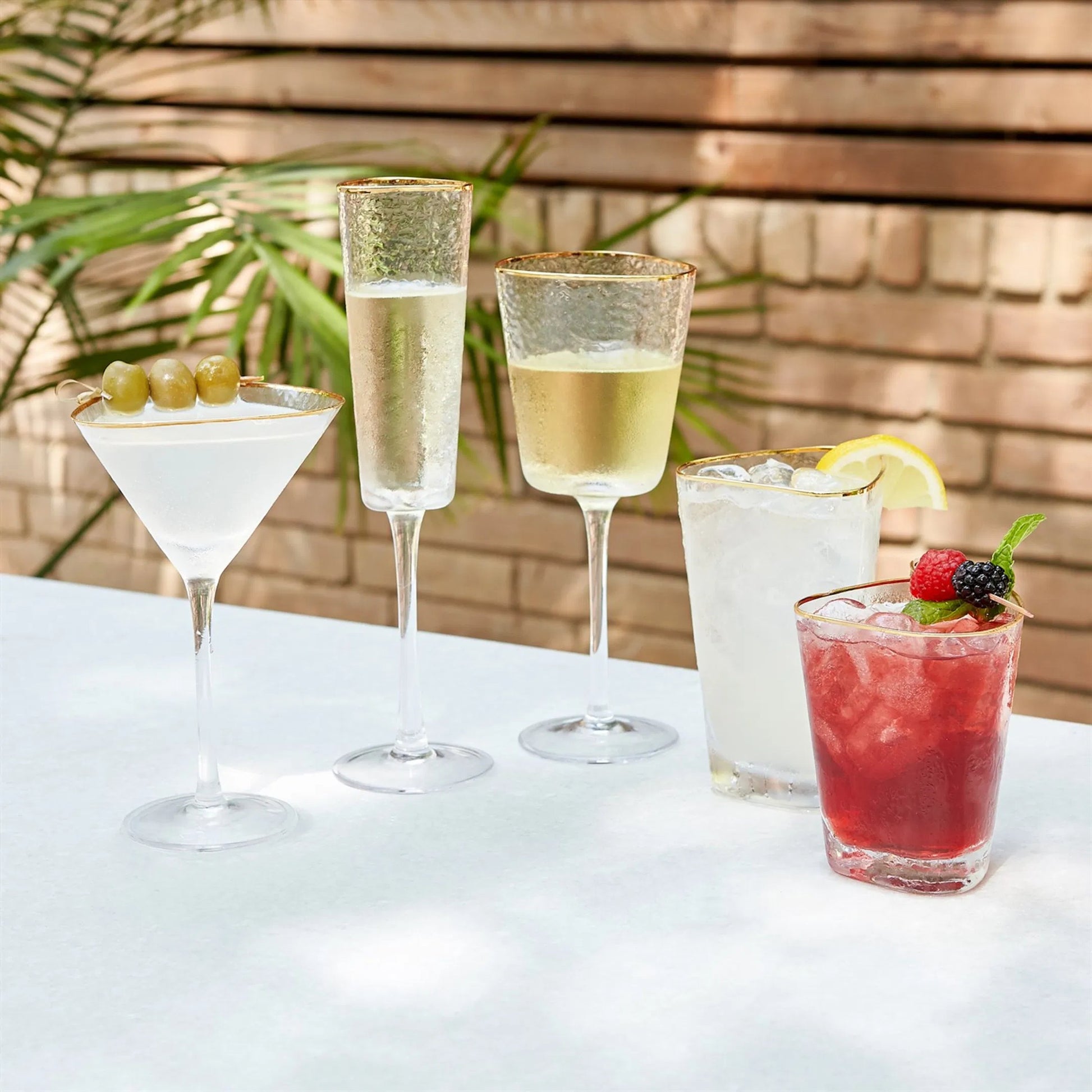 Hammered Champagne Glasses by Global Views in clear w, gold rim. Made from glass in a transitional style.