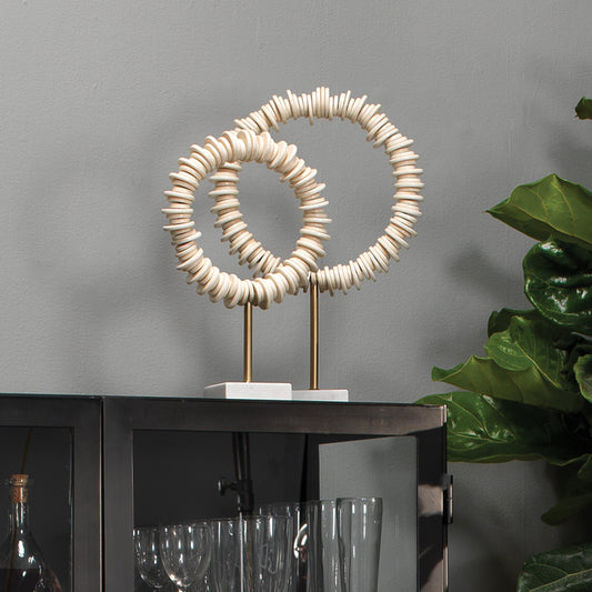 Arena Ring Sculptures by Jamie Young in cream resin, antique. brass rod, white marble base. Made from resin, iron, white marble in a coastal style.