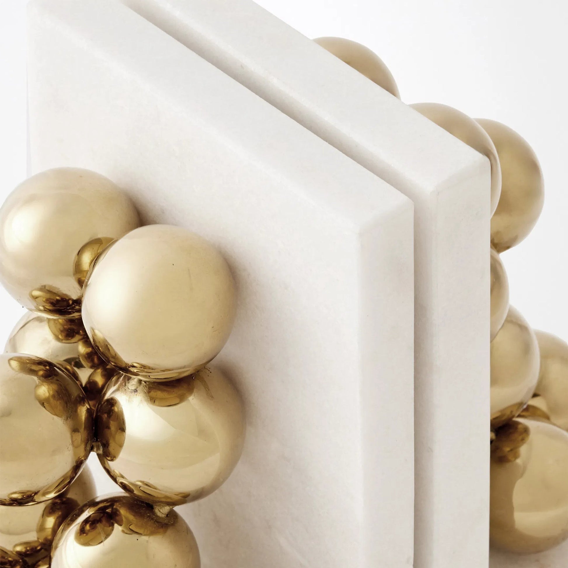 Sphere Bookends by Global Views in brass. Made from faux gold ball, white marble in a modern style.