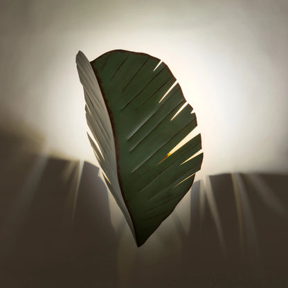 Sconce by Varaluz in banana leaf. Made from banana leaf, recycled steel in a coastal style.