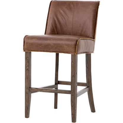 Aria Counter Stool by Four Hands in sienna chestnut. Made from top grain leather, solid nettlewood, 100% polyester in a modern style.