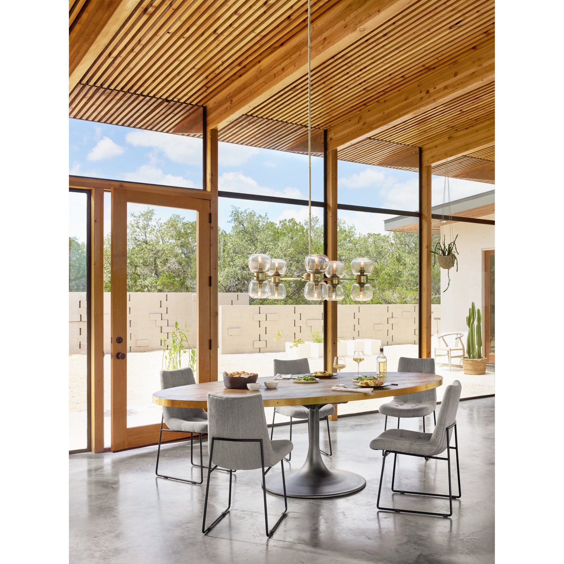 Evans Oval Dining Table by Four Hands in reclaimed burnt oak, vessel grey, polished brass. Made from solid reclaimed oak, iron, stainless steel in a modern style.