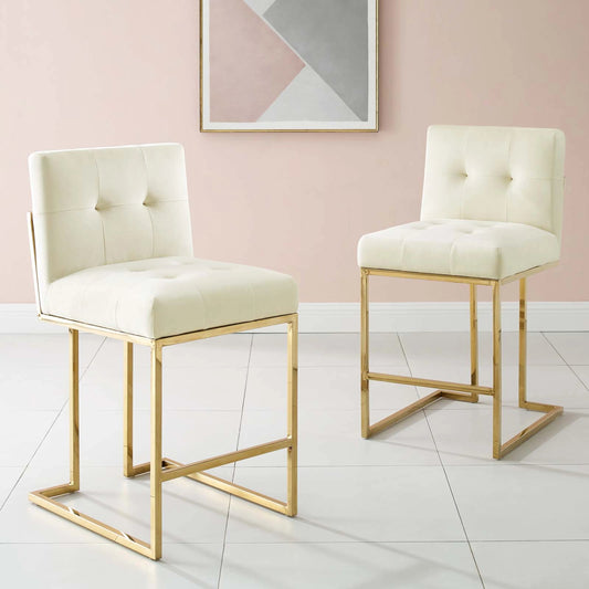 Pinal Gold Counter Stool (Set of 2) by Evans & Londeen in gold ivory. Made from yuhua velvet fabric, plywood, 2 layers of foam, stainless steel square tube chromed, polyester in a modern style.