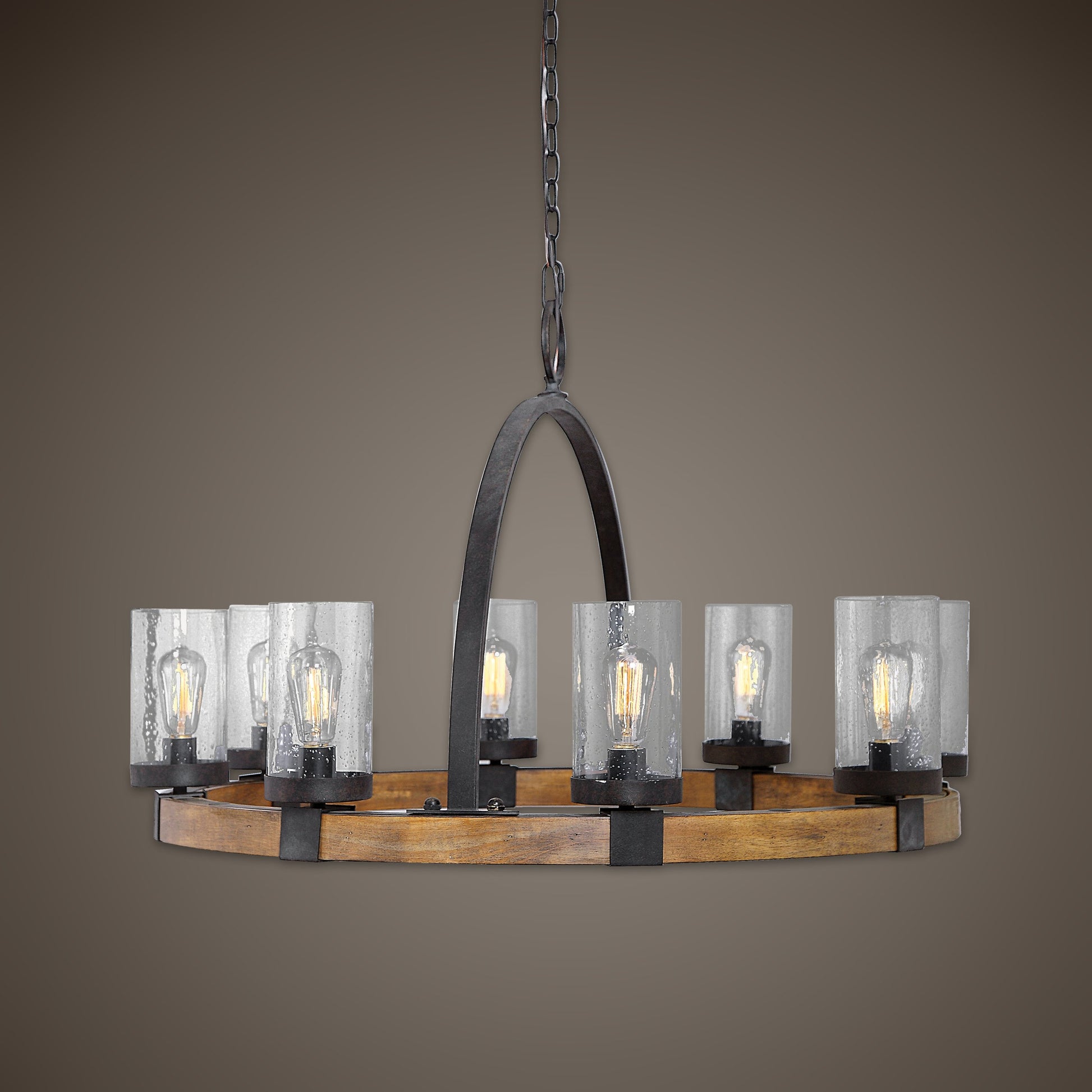 Atwood Wagon Wheel Pendant by Uttermost. Made from steel, rubber wood, glass in a rustic style.