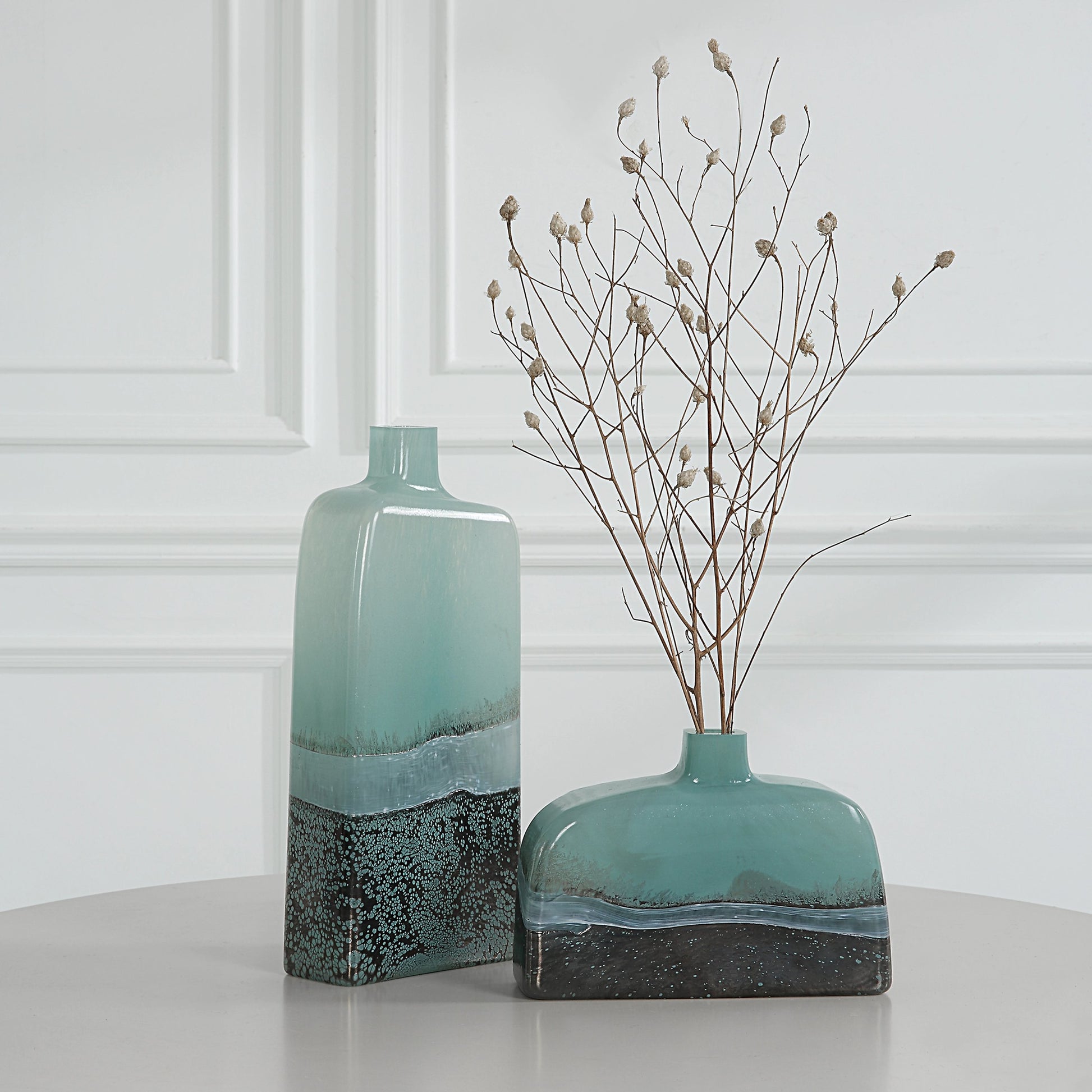 Fuze Vases by Uttermost in aqua, bronze. Made from glass in a modern style.