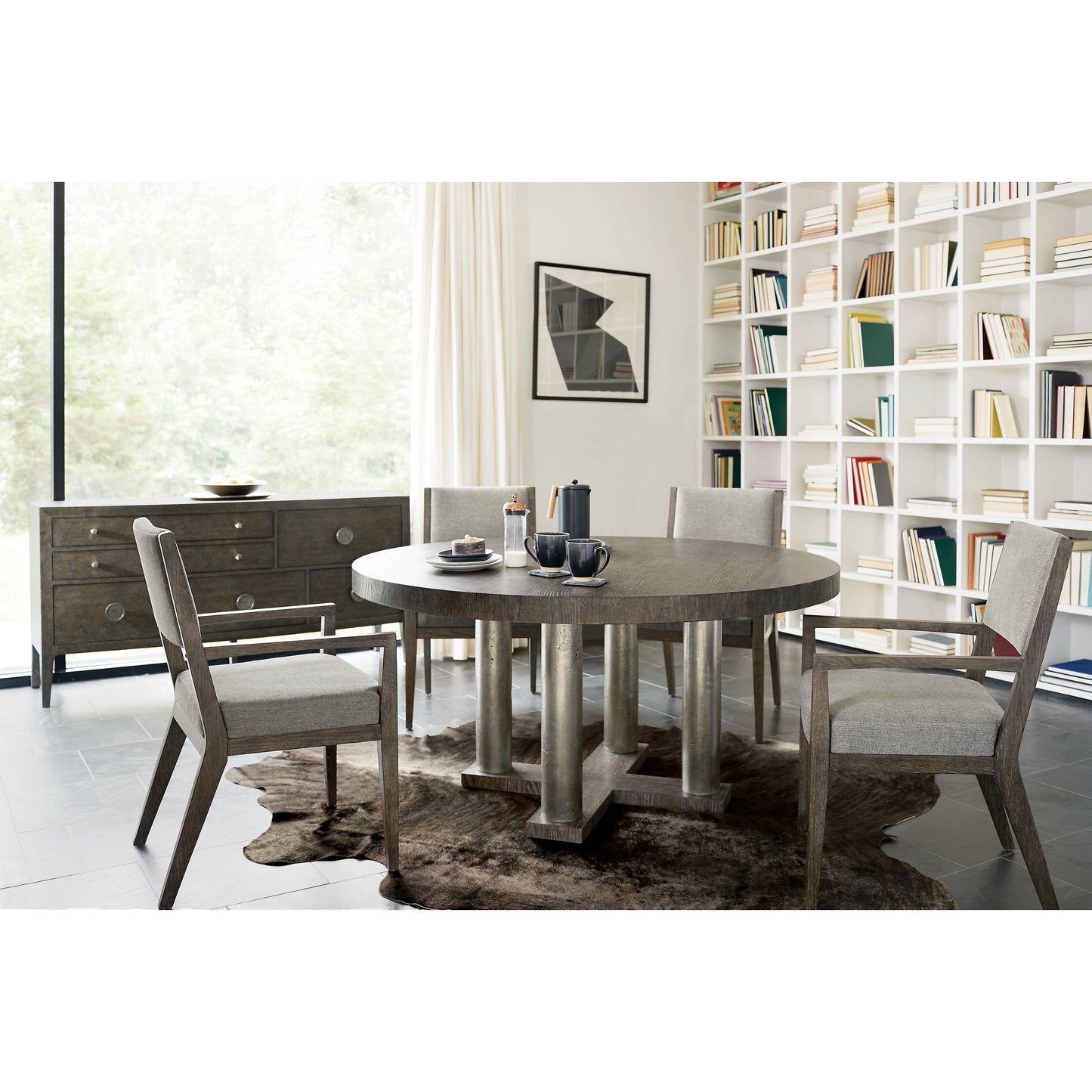 007 SI-1711408 | Lifestyle | Linea Round Dining Table by Bernhardt in cerused charcoal, textured graphite metal. Made from white oak veneers, cast aluminum in a unique style.