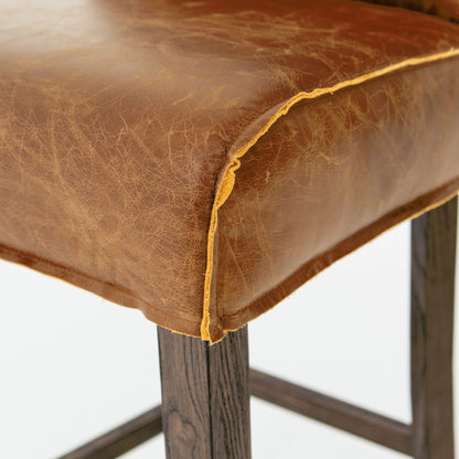 Aria Counter Stool by Four Hands in sienna chestnut. Made from top grain leather, solid nettlewood, 100% polyester in a modern style.