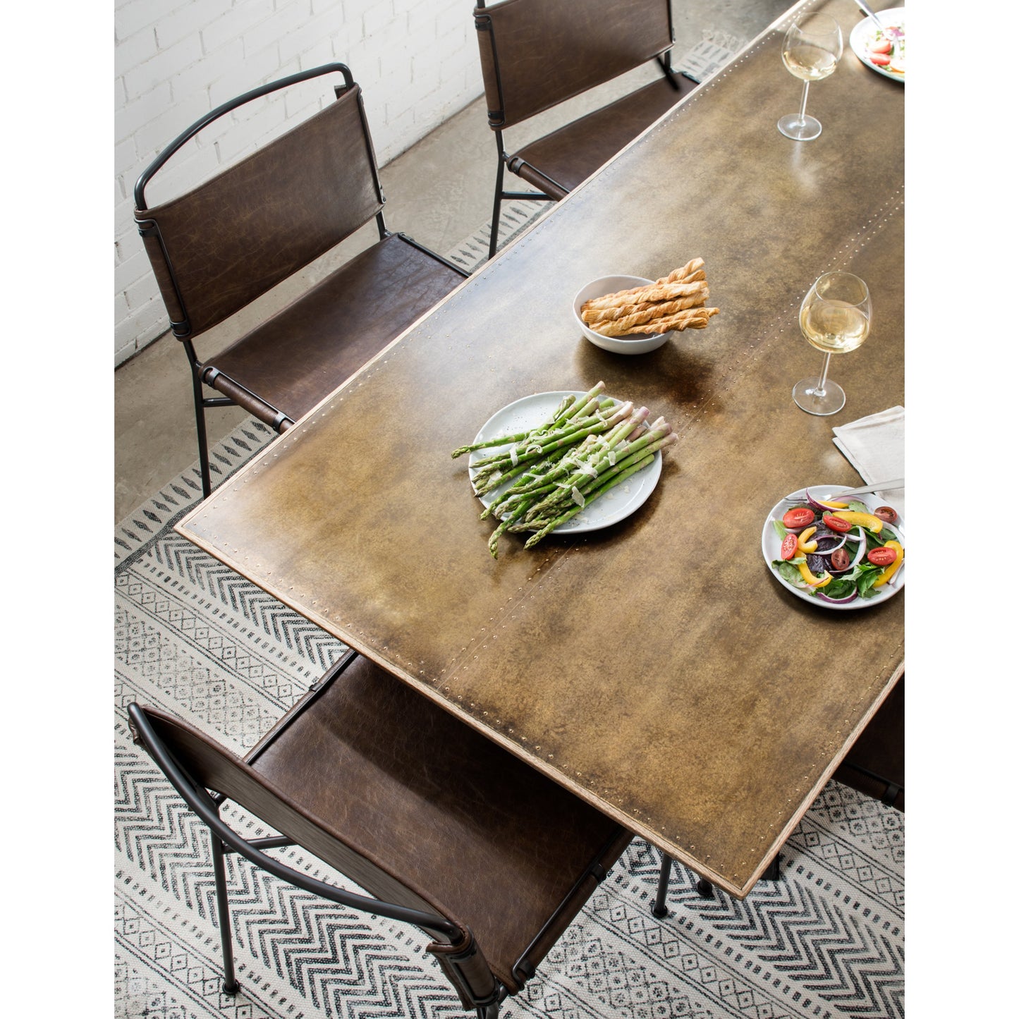 015 S-258375 | Lifestyle | Spider Dining Table by Four Hands in light rustic black, bright brass clad, sandy oak. Made from brass, iron, solid oak in a cottage & farmhouse style.