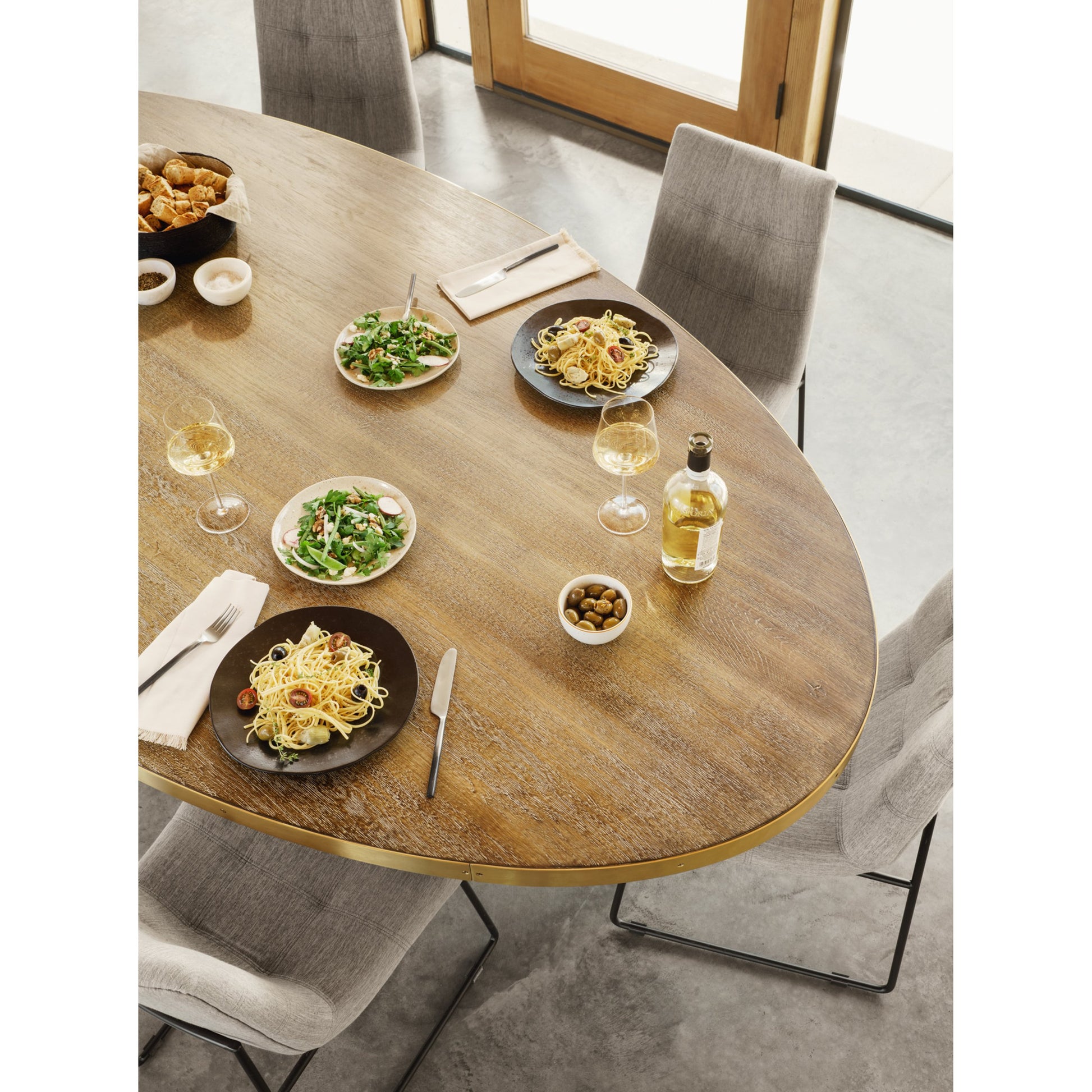 Evans Oval Dining Table by Four Hands in reclaimed burnt oak, vessel grey, polished brass. Made from solid reclaimed oak, iron, stainless steel in a modern style.