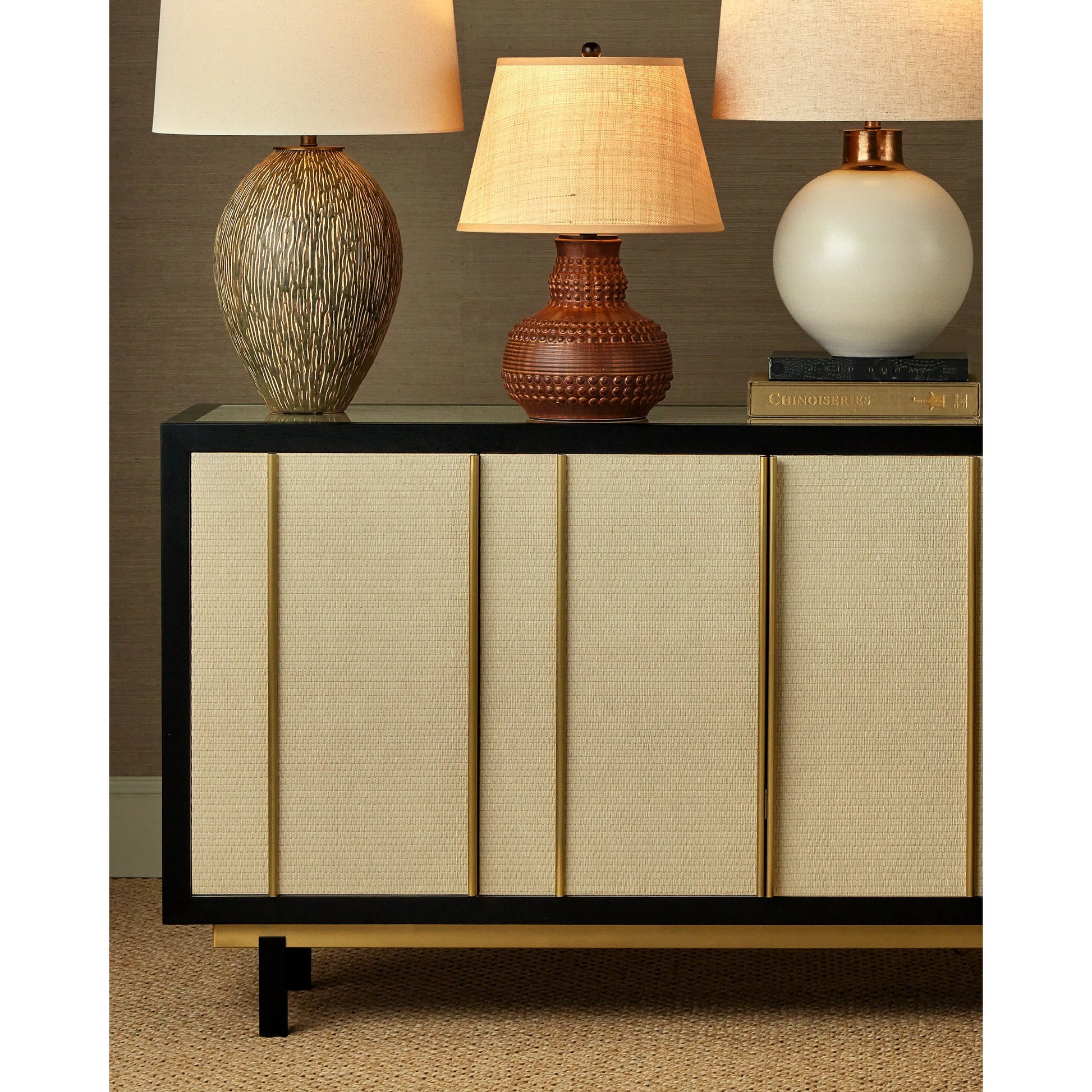 Deanna Raffia Credenza by Currey and Company in ivory, black, satin brass, natural, clear. Made from raffia, okume veneer, stainless steel, sycamore veneer, tempered glass in a modern style.
