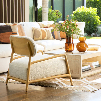 Donney Occasional Chair by Arch & Plane in cream boucle upholstery, natural wood. Made from polyester blend upholstery, mindi wood frame in a unique style.