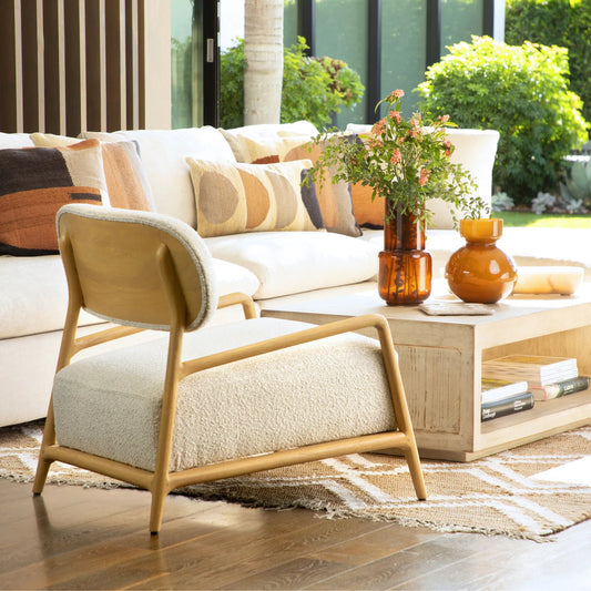 Donney Occasional Chair by Arch & Plane in cream boucle upholstery, natural wood. Made from polyester blend upholstery, mindi wood frame in a unique style.