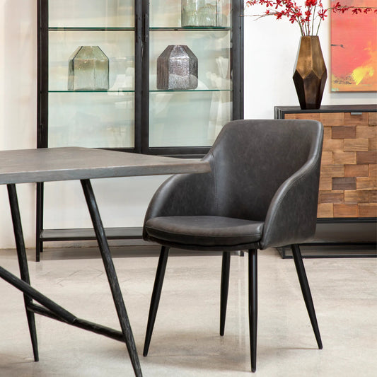 Edda Dining Chair by Arch & Plane in antique brown upholstery, black powder coated legs. Made from pu leather upholstery, metal legs in a unique style.