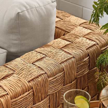 Volusia Rattan Armchair by Evans & Londeen in natural light gray. Made from rattan in a rustic style.