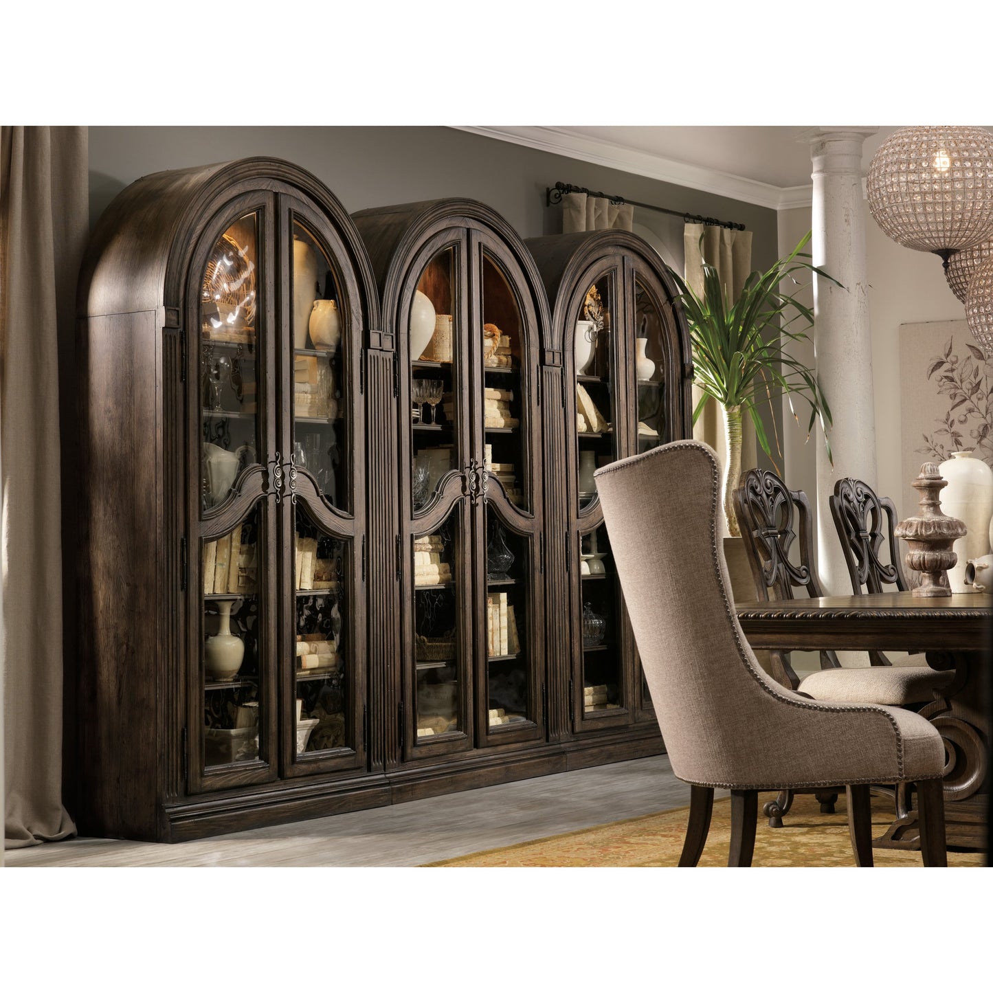 001 SI-1749454 | Lifestyle | Rhapsody Curio Cabinet by Hooker Furniture in rustic walnut. Made from pecan veneers, metal, seeded glass, resin in a traditional style.