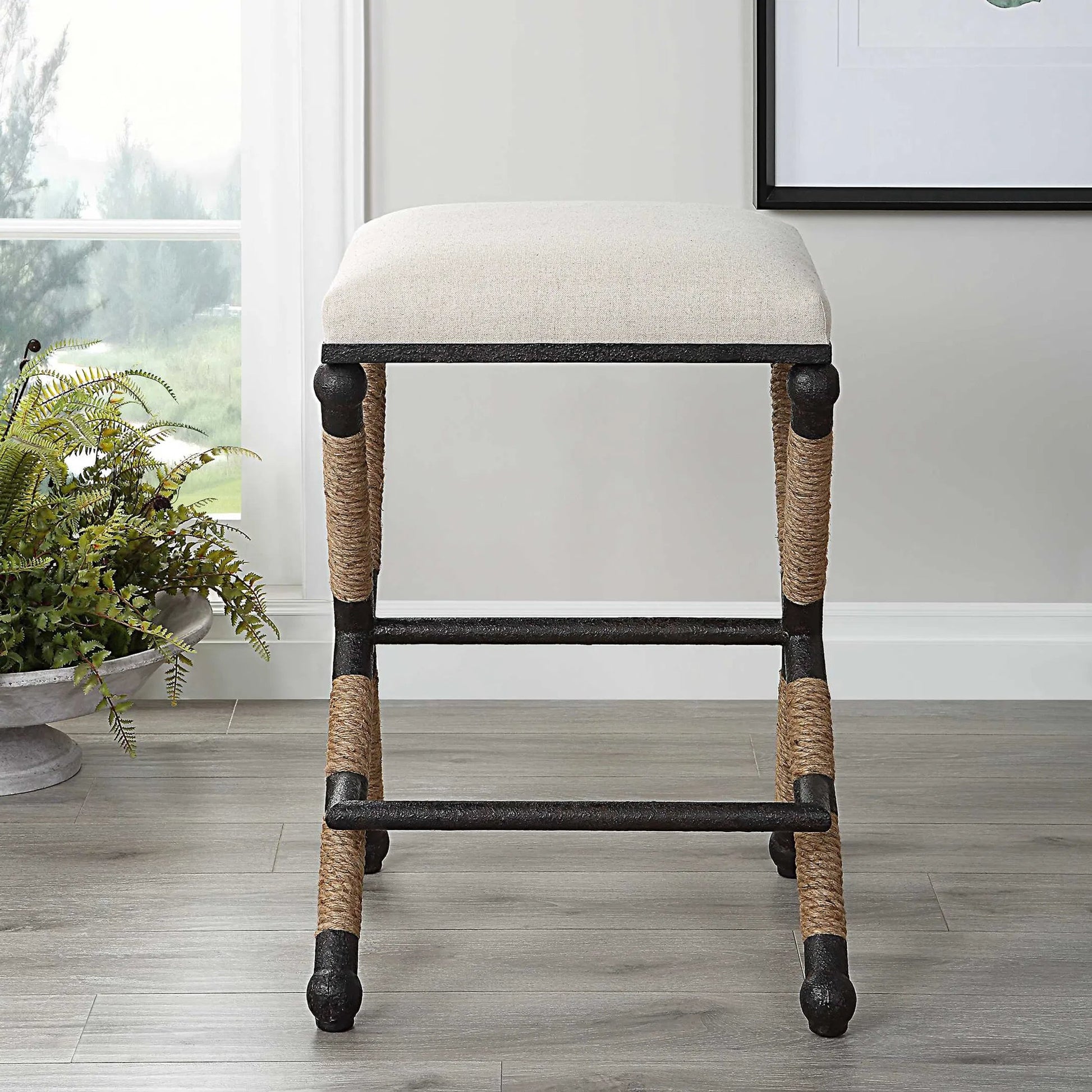 Firth Rustic Oatmeal Counter Stool by Uttermost in black, natural. Made from mdf, farbic, iron, foam, rope in a coastal style.