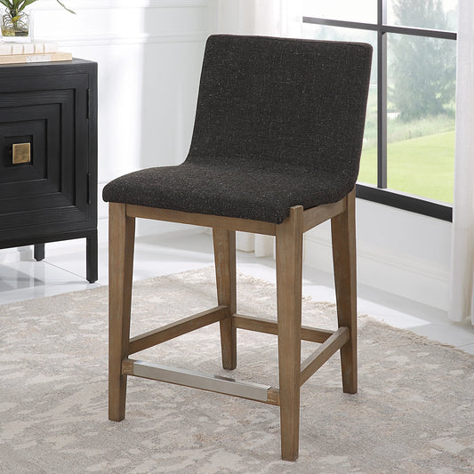 Klemens Counter Stool by Uttermost in charcoal brown and walnut. Made from rubber wood，plywood，fabric，foam，hardware in a modern style.