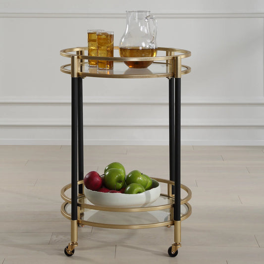 Dolly Round Bar Cart by Uttermost in gold leaf. Made from iron, tempered glass in a modern style.