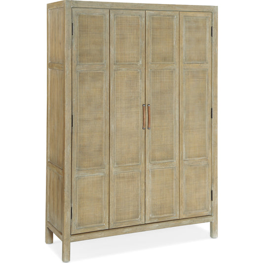 Surfrider Bar Cabinet by Hooker Furniture in driftwood. Made from pecan veneers, rattan, glass, puck light, self-closing undermount drawer guides in a cottage & farmhouse style.