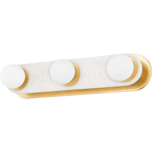 Zora 3 Light Bath Sconce by Mitzi in aged brass. Made from brass in a modern style.