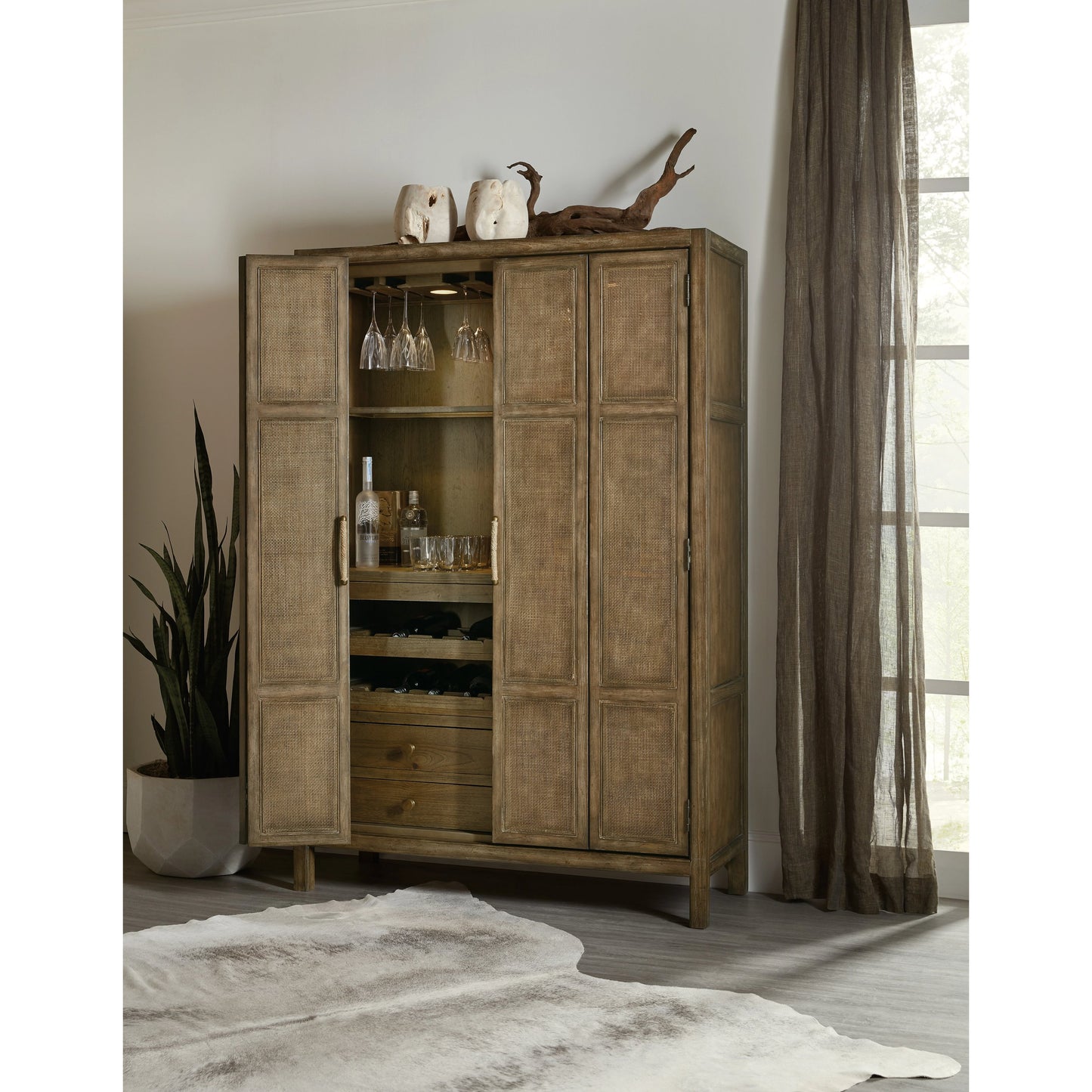 012 SI-1749788 | Lifestyle | Sundance Bar Cabinet by Hooker Furniture in cliffside. Made from pecan veneers, rattan, glass, puck light, self-closing undermount drawer guides in a transitional style.