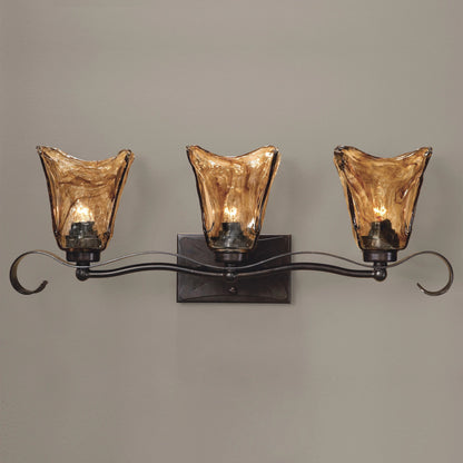 Vetraio Vanity Strip by Uttermost in bronze. Made from metal, brass, glass in a rustic style.
