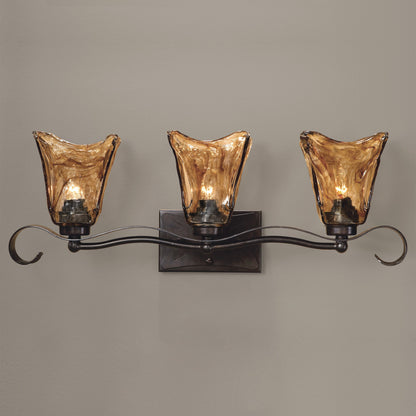 Vetraio Vanity Strip by Uttermost in bronze. Made from metal, brass, glass in a rustic style.