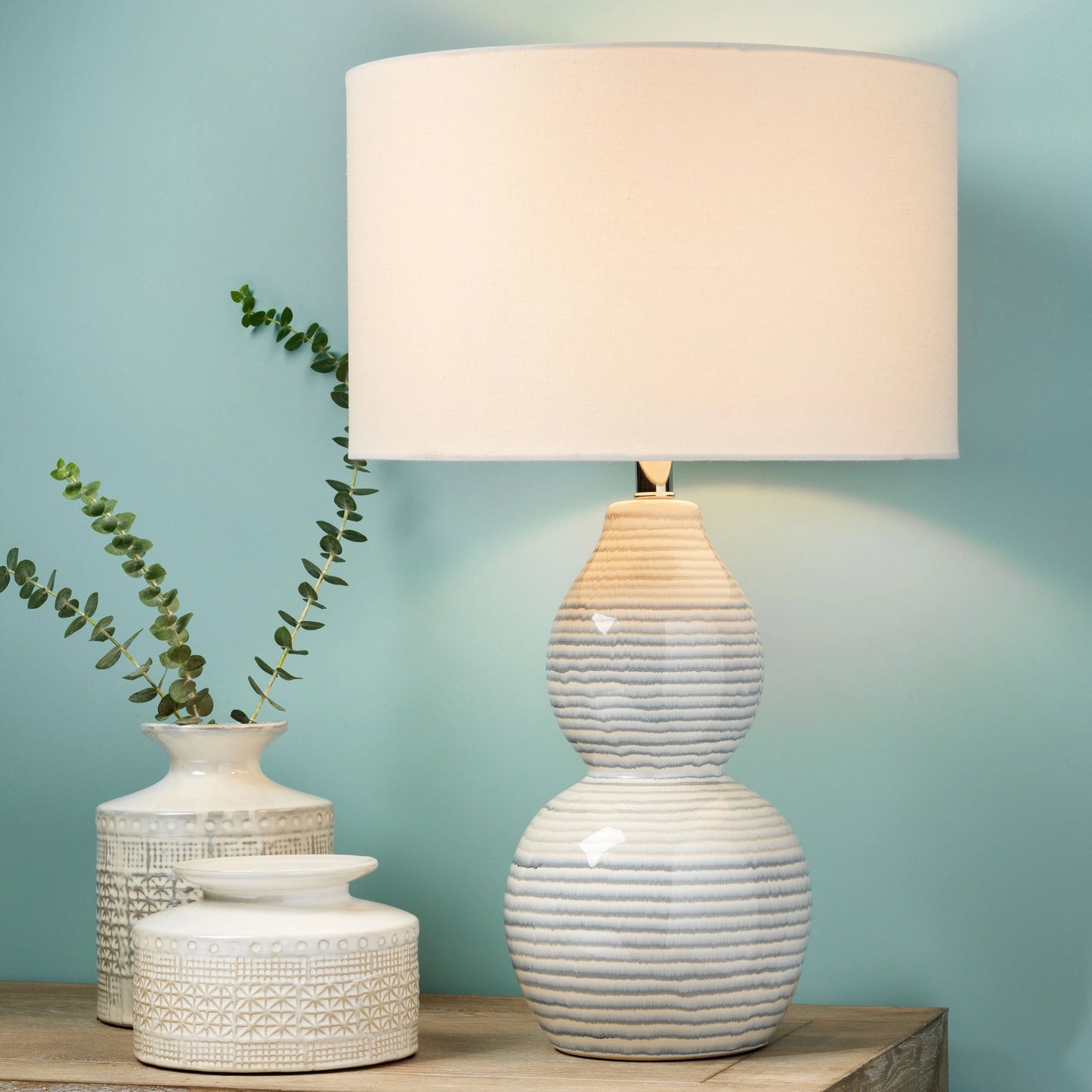 004 SR-819631 | Lifestyle | Catalina Wave Table Lamp by Jamie Young in white, blue patterned ceramic. Made from ceramic, linen in a modern style.