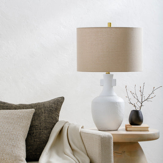Mauna - 500118 by Surya in body: white, shade: wheat, finial: metallic - brass, harp: metallic - brass, cord: translucent and colored, polished. Made from body: ceramic, shade (outside): linen, shade (inside): polyester, finial
