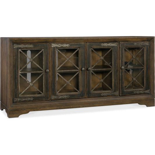 Pipe Creek Media Console by Hooker Furniture in saddle brown, anthracite black. Made from white oak veneers with antique seeded glass, metal in a rustic style.