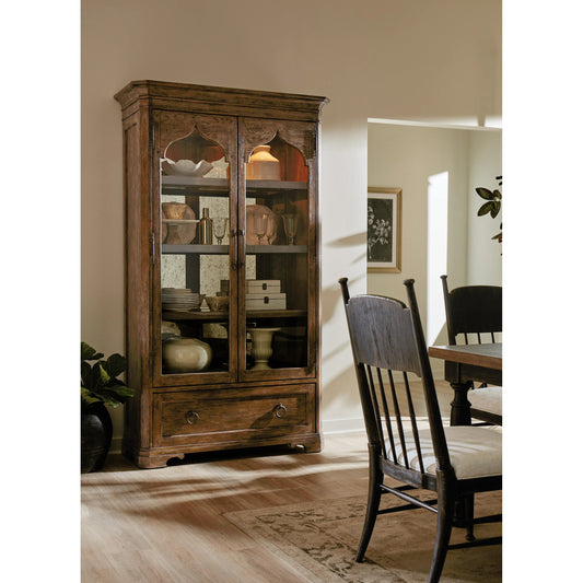 Americana Display Cabinet by Hooker Furniture in brown and honey finish. Made from oak veneers with light, tempered glass in a cottage & farmhouse style.