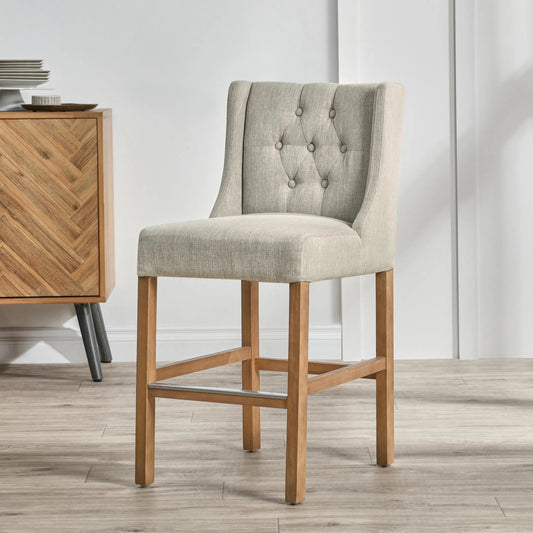 Karla Tufted Counter Stool by Kosas Home in french beige upholstery, natural brown legs. Made from blended upholstery (57% polyester 25% viscose 18% linen), rubber wood legs in a transitional style.