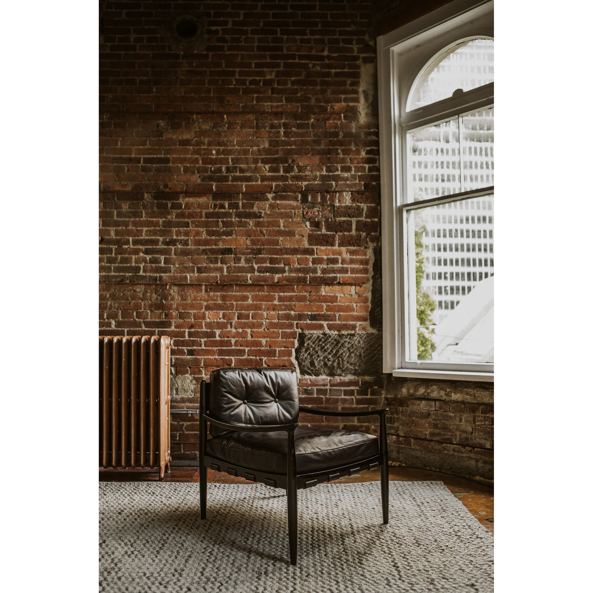 Turner Chair by Moe's Home Collection in black. Made from ash wood frame, top-grain buffalo leather, foam cushion with a feather wrap in a modern style.