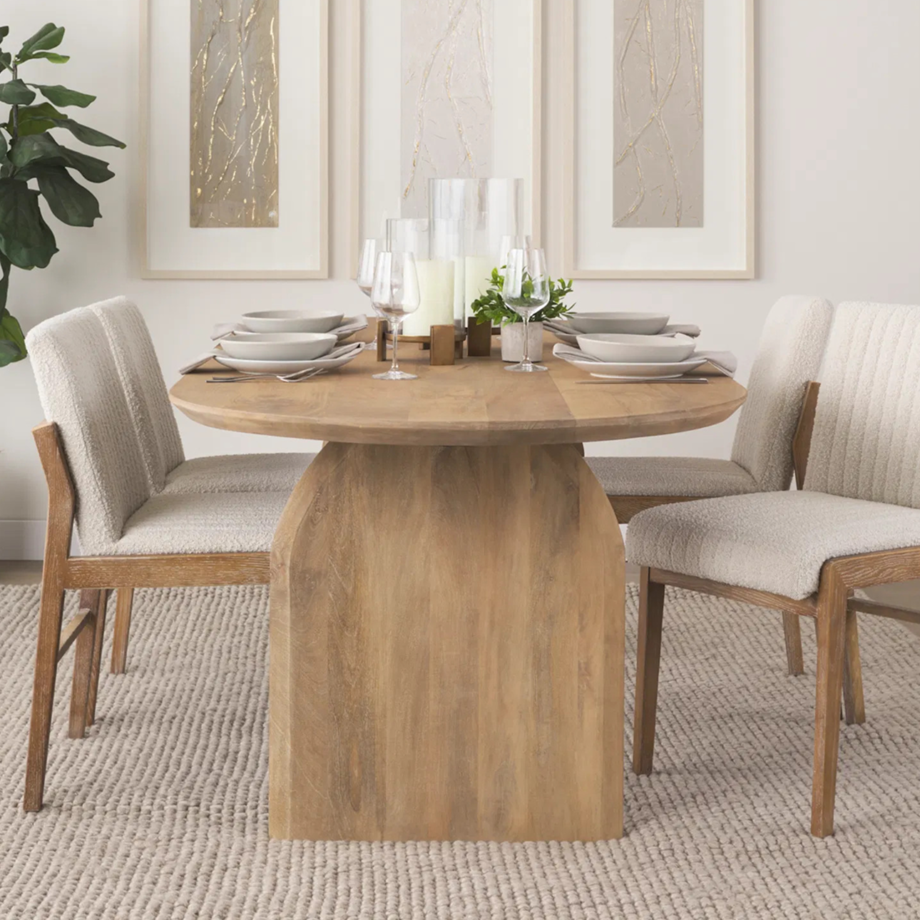 Round wood dining table with sculptural base and upholstered chairs, styled in a neutral dining room with elegant table settings—available now on sale.