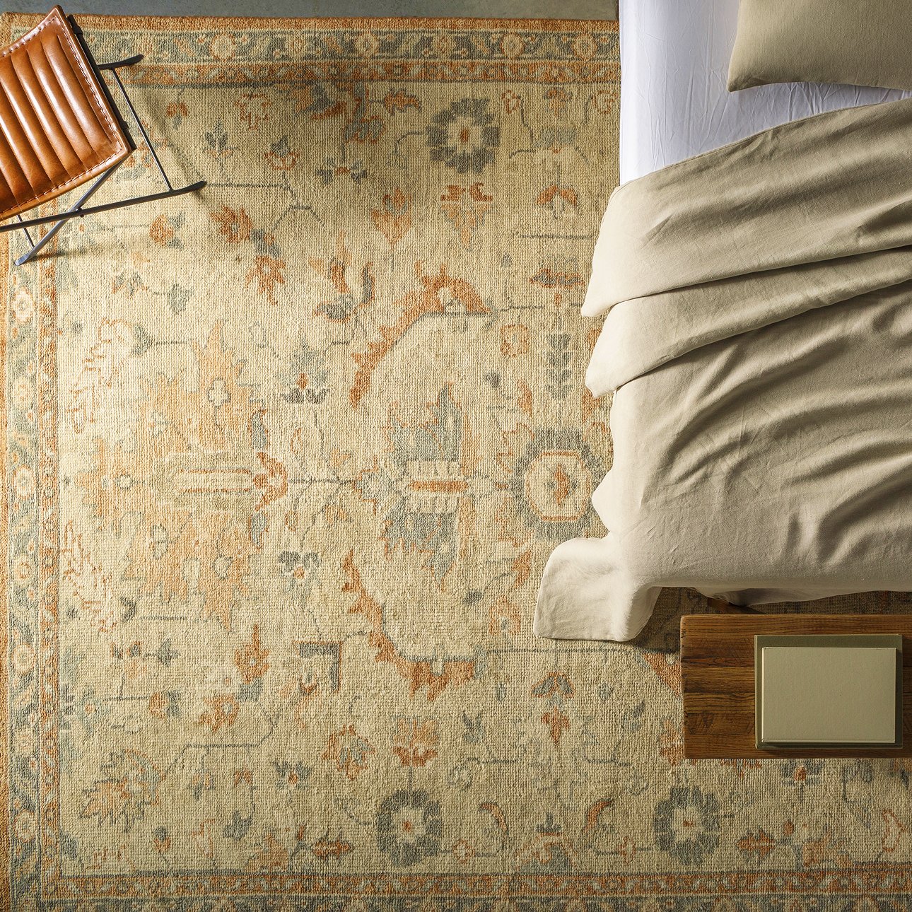 Vintage-inspired area rug in soft earth tones styled under a bed in a cozy bedroom, perfect for adding warmth and character to your space—now on sale.