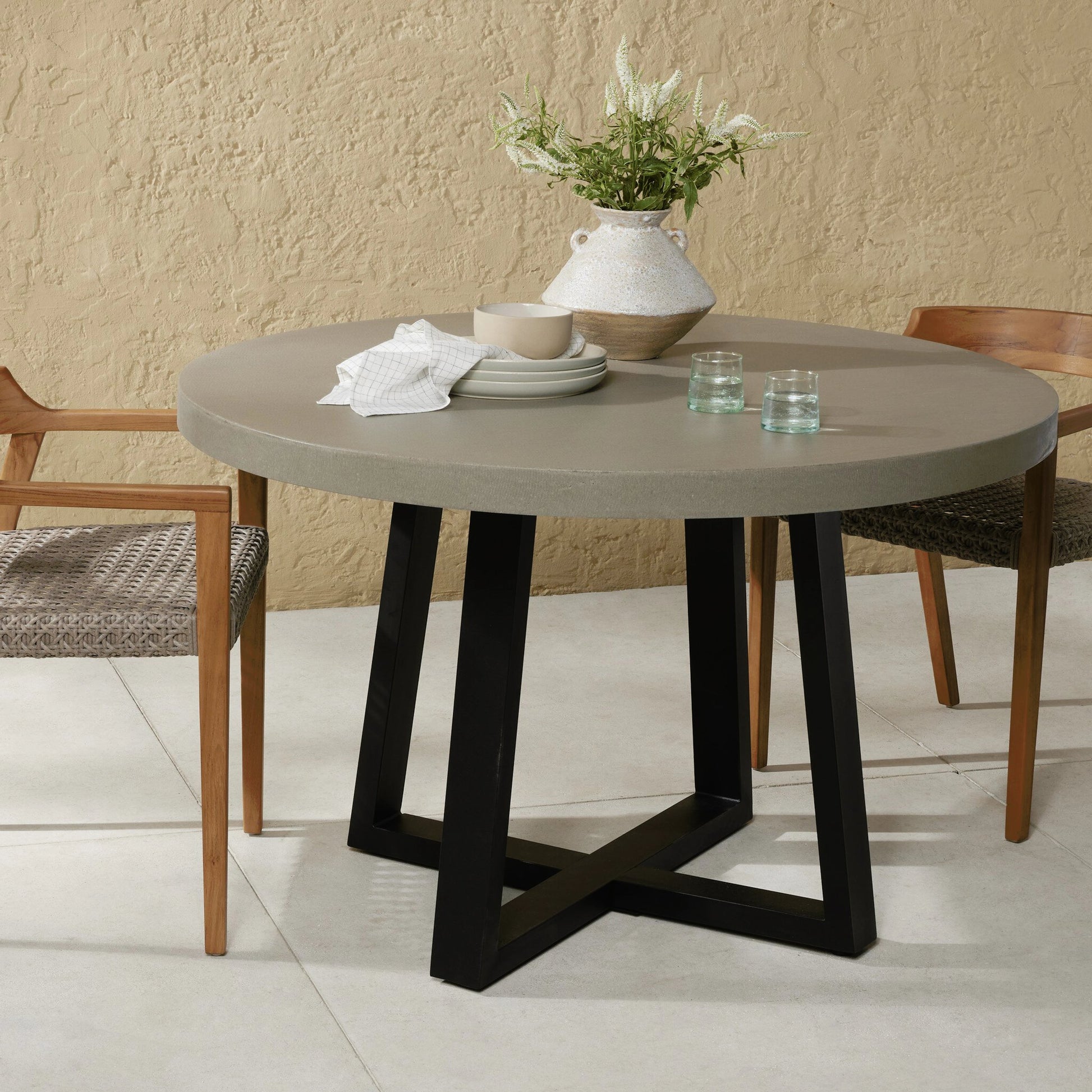 Cyrus Outdoor Round Dining Table by Four Hands. Made from lavastone composite, iron in a modern style.