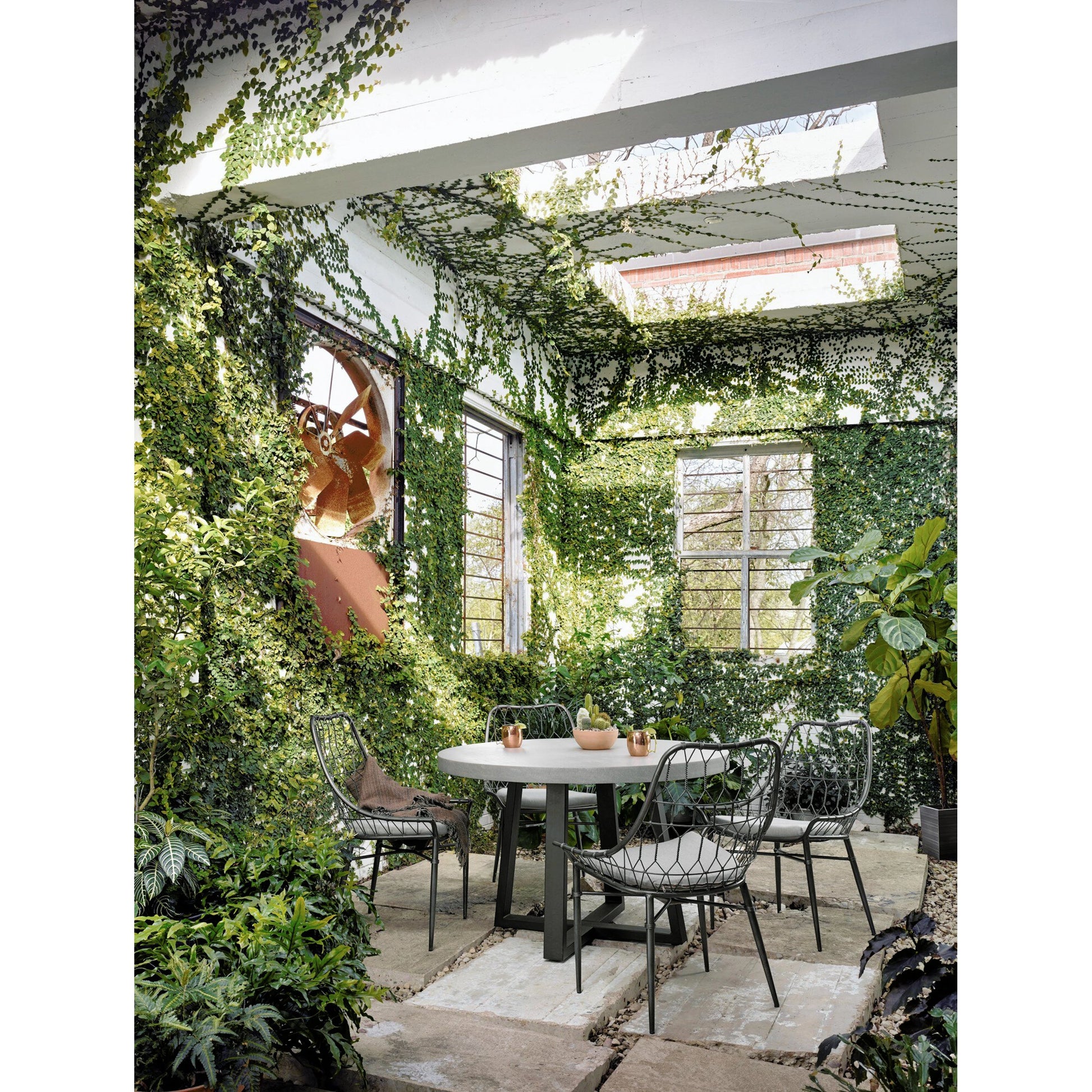 Cyrus Outdoor Round Dining Table by Four Hands. Made from lavastone composite, iron in a modern style.